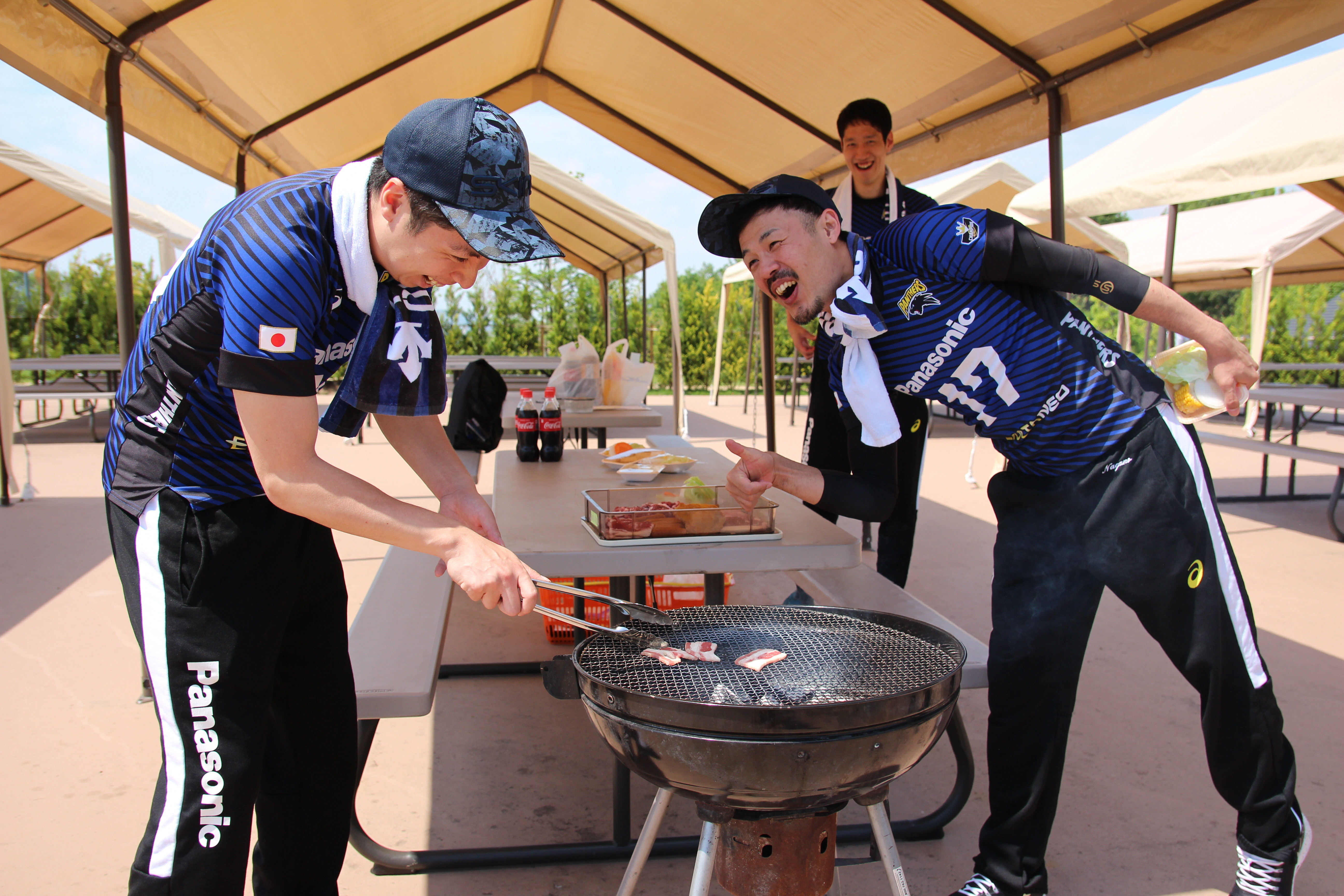 選手が肉を焼いている写真