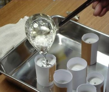 溶けた金属を鋳型に流し込む画像