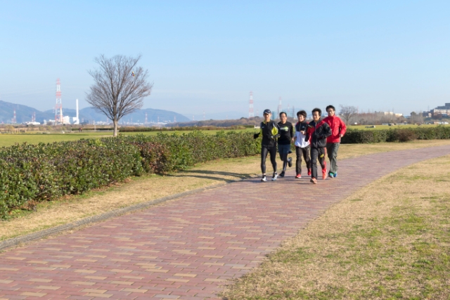 淀川河川公園の沿道を散歩する人たちの写真。