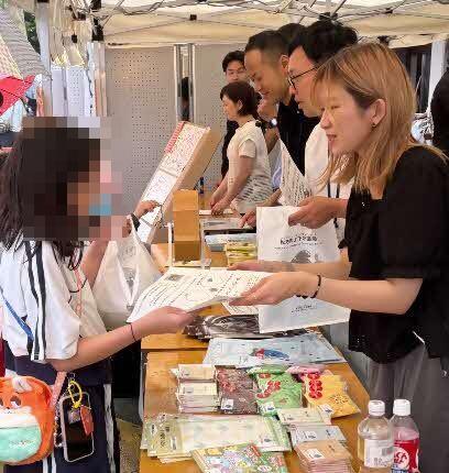 シールラリー台紙を渡しているところ